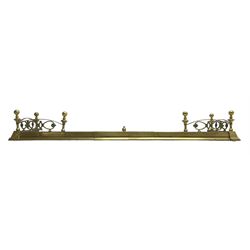 Early 20th century brass telescopic fire fender, turned finials and arched rails enclosing scrolling mounts with foliate decoration 