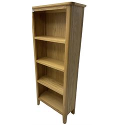 Contemporary light oak open bookcase, fitted with three shelves, on tapering supports