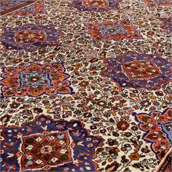 West Persian Hamadan hand-knotted rug, ivory field decorated with a repeating lattice of stylised geometric medallions interspersed with small floral motifs and angular vine ornament enclosed by a sky blue border of stylized rosettes and geometric devices between multiple guard stripes, with cotton fringe ends  