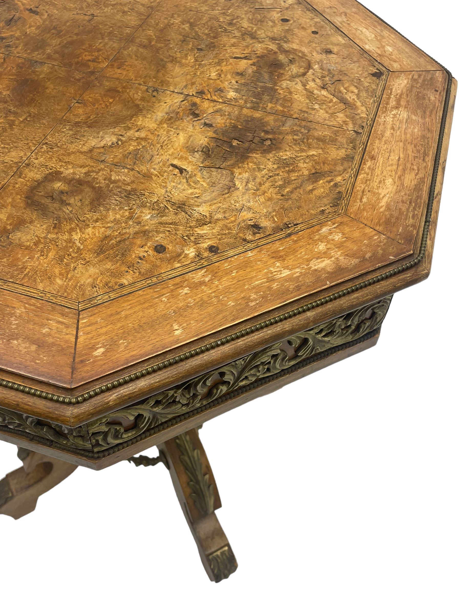 Mid-20th century figured walnut Italian design centre table, octagonal quarter veneered top with cross banding and moulded edge, the skirt decorated with scrolling foliage gilt metal mounts, on turned pedestal mounted with gilt acanthus leaves, quadruple splayed supports with further acanthus leaf decoration