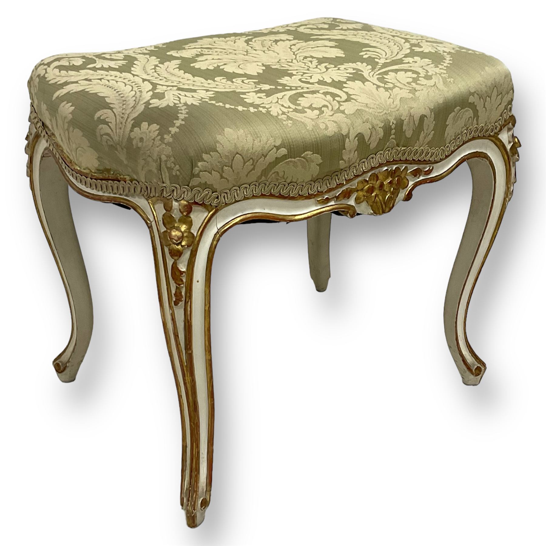 20th century French design parcel gilt and painted dressing table stool, upholstered in sage green damask fabric, shaped form on floral carved cabriole supports, with matching cushion 