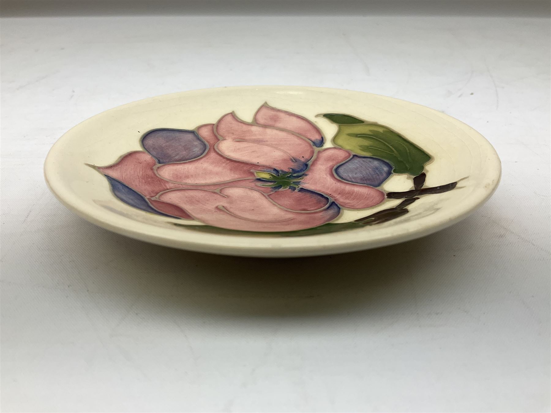 Moorcroft pin dish decorated in the Pink Magnolia pattern on a cream ground, D12cm