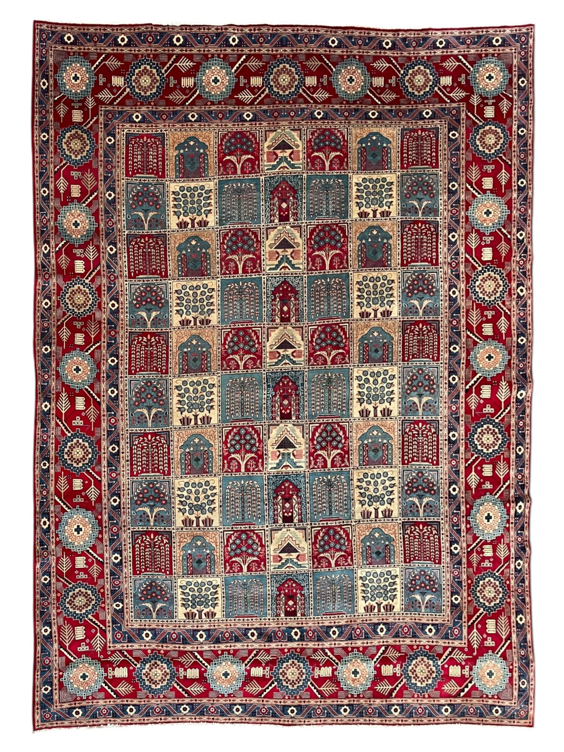 Persian Bakhtiari crimson ground carpet, the field divided into seventy panels decorated tree of life motifs, mihrabs and stylised plants, the border decorated with repeating circular medallions formed of Hac motifs, floral pattern guard stripes 