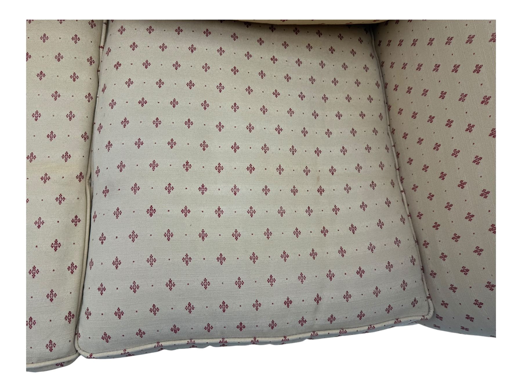 20th century Knole design two seat sofa, high back and double drop-arm joined by mahogany finials and ties, upholstered in camel ground fabric with red lozenge design, on turned supports with brass castors