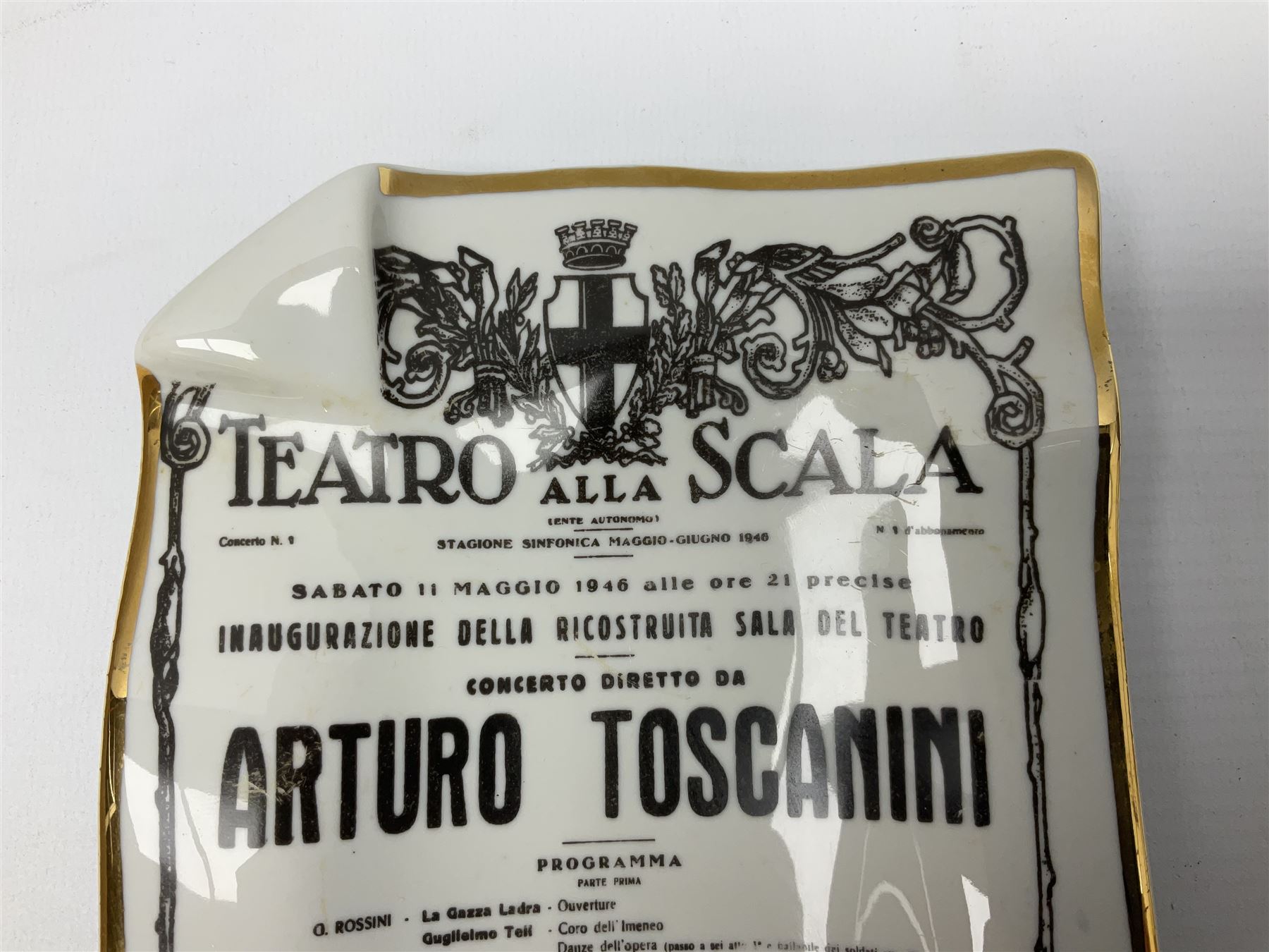 Fornasetti rectangular 'Toscanni's Concert' poster ashtray decorated with black and white text with a gilt border edge, with printed mark beneath, H22cm 