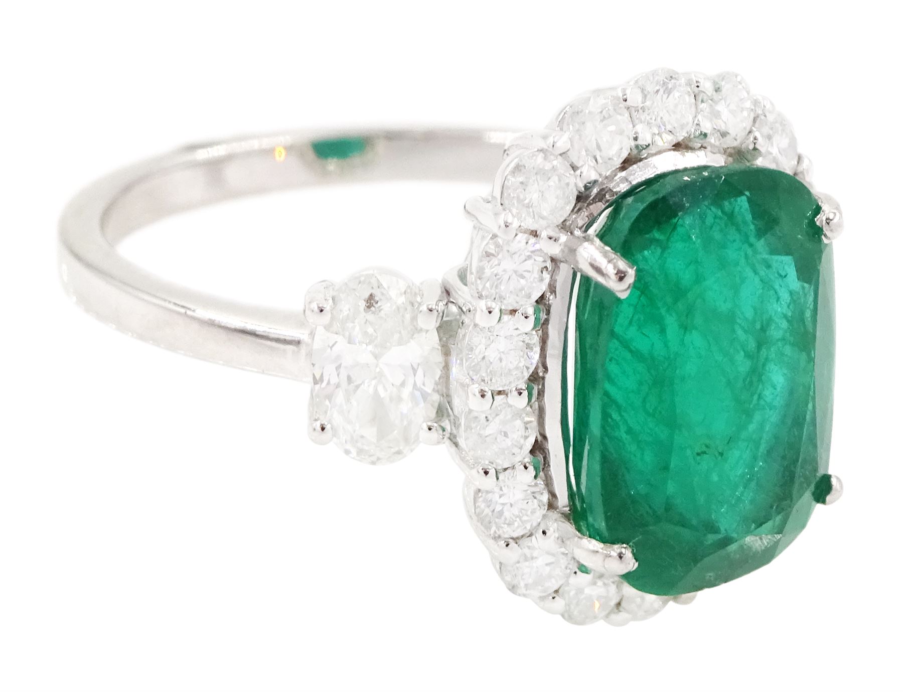 18ct white gold emerald and diamond cluster ring, single cushion cut emerald of approx 2.45 carat, surrounded by eighteen round brilliant cut diamonds, with a single oval cut diamond set either side, stamped, total diamond weight approx 1.05 carat