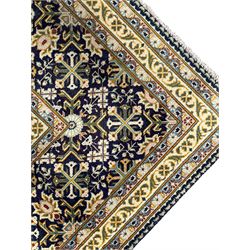 Persian indigo and pale gold ground rug, overall busy geometric design, the field decorated with hooked Hac and palmette medallions surrounded by densely patterned zig-zags and stylised foliate motifs, the border decorated with smaller Hac motifs, within multiple guard stripes 