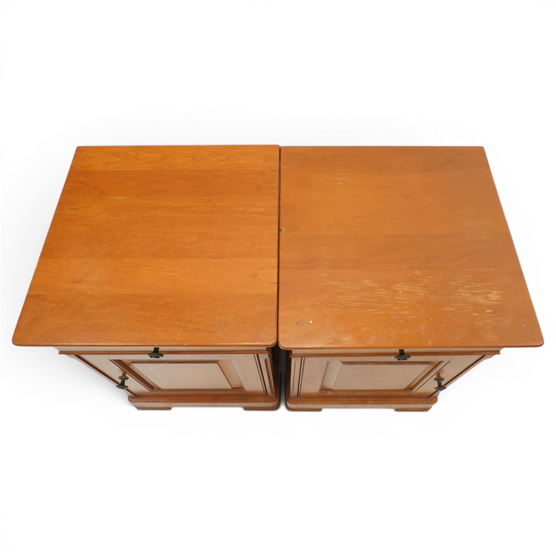 St Michael - pair of cherrywood bedside tables, single drawer above a fielded panel door, brass pulls, raised on a plinth base
