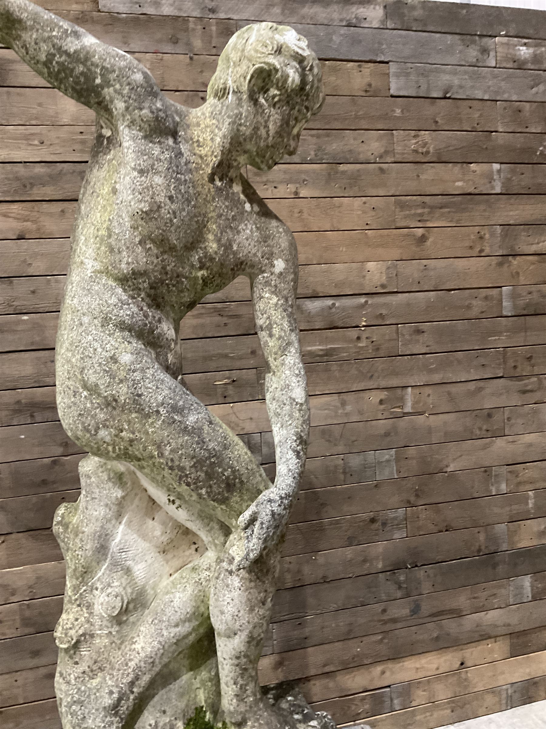Life-size weathered cast stone Greek Discus Athlete, seated on rectangular slab raised on associated architectural plinth