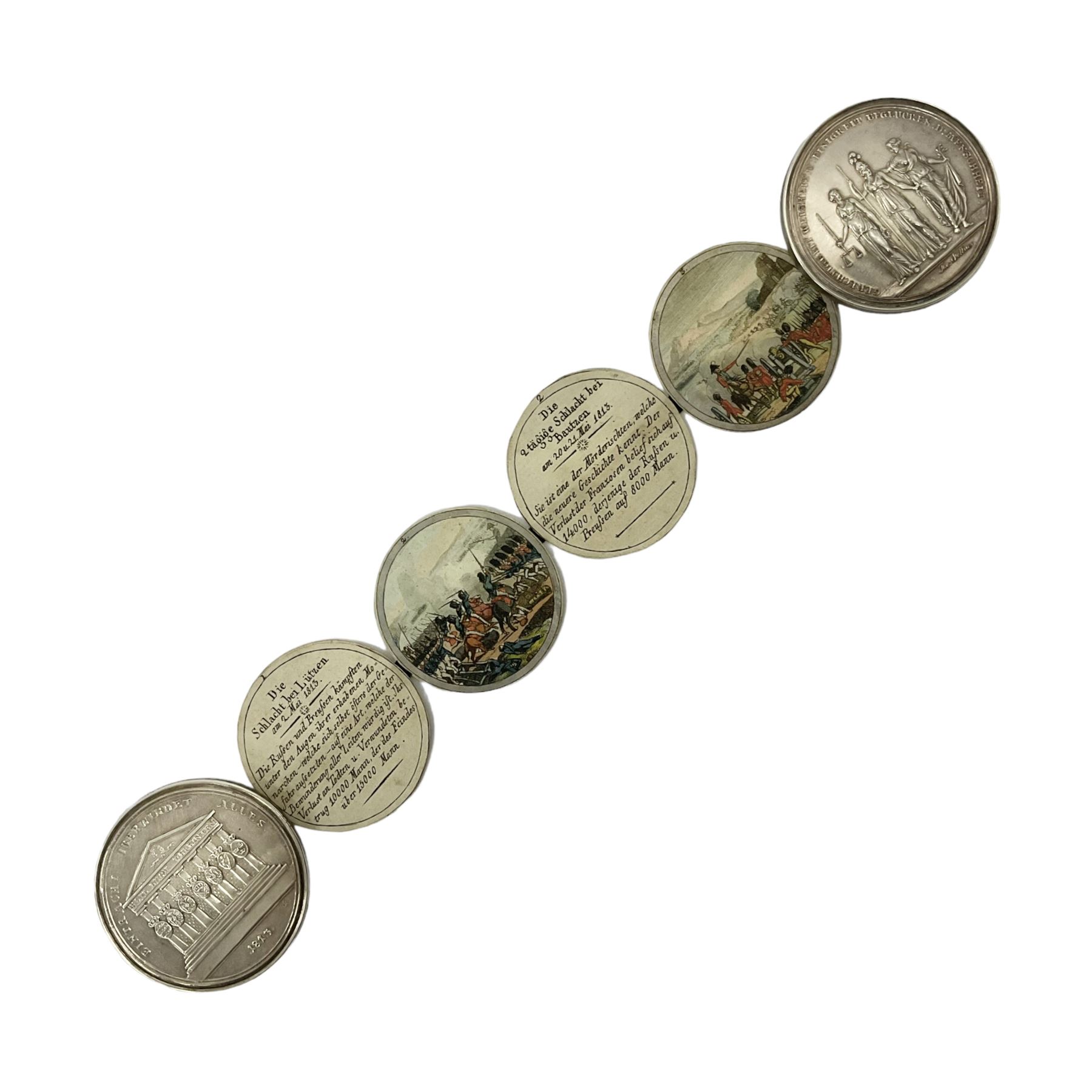 Grolier Club’s silver Schraubmedaille to commemorate the German campaign of 1813, obverse depicts a Greek temple, below “Eintracht Überwindet Alles”, the reverse depicts three figures and the text “Gerechtigkeit. Weisheit. U. Einigkeit. Beglücken. D.: Menschheit”, inside are twelve circular hand coloured engravings depicting six major battles of the German campaign, each with corresponding descriptions, D