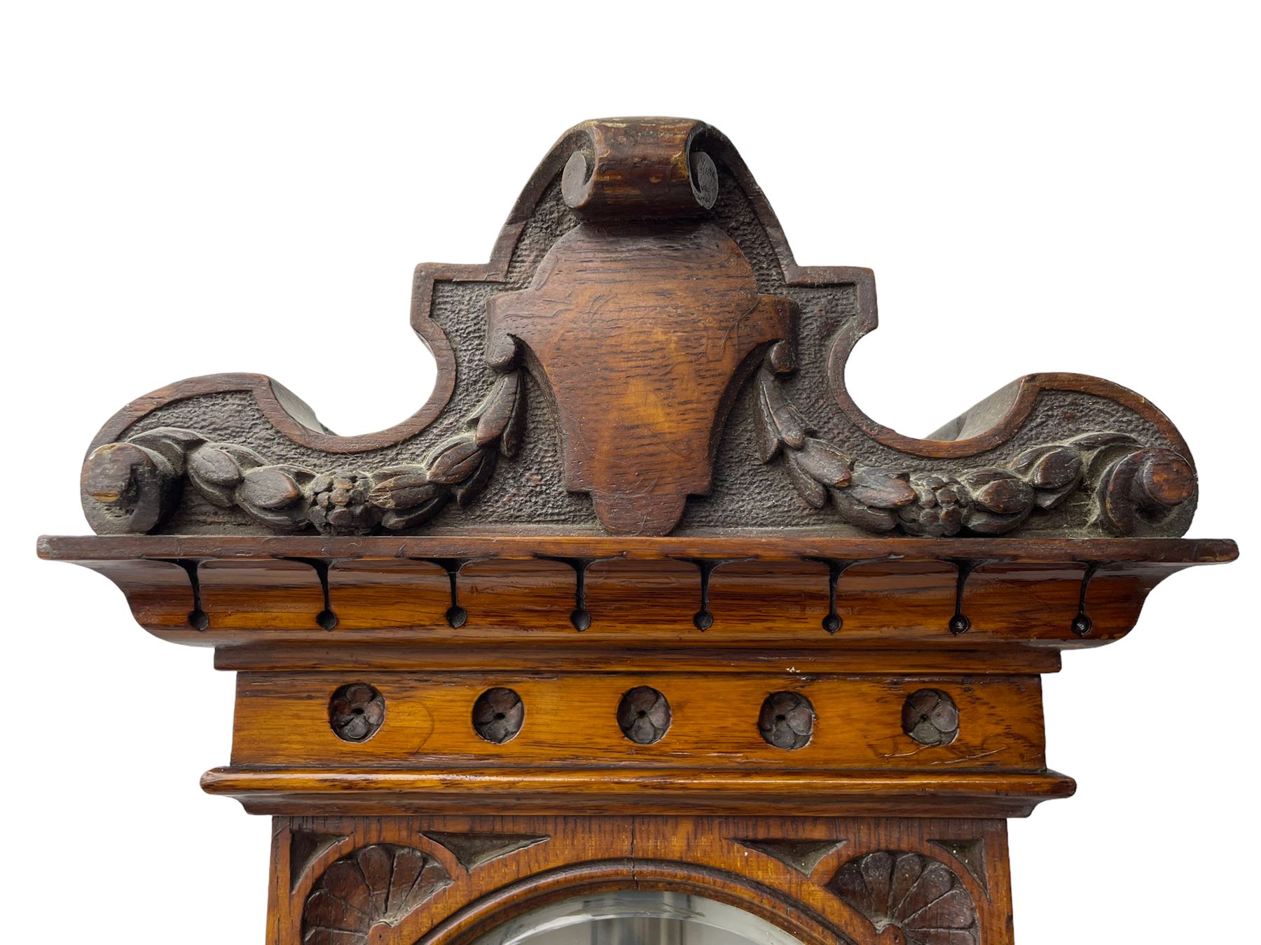 J Hicks - Hatton Garden London, - late 19th century carved oak cased Fitzroy barometer in a richly carved case with a carved crested pediment and square cistern cover, inverted opaline register reflecting FitzRoy's predictions and a scale from 27 to 31 inches of barometric pressure, with a thick bore cistern tube and adjustable rack and pinion twin vernier, fitted with a glazed snail bulb mercury thermometer recording the air temperature in both Fahrenheit and Celsius. Mercury clean and present.
James Joseph Hicks was born in Ireland, however, early in his life he moved to London where he was apprenticed to the instrument maker Louis P Casella. In 1860 he went into business in his own right as a scientific instrument maker at 8 Hatton Gardens. In 1864 he was granted membership to the British Meteorological Society and exhibited instruments at the Royal Society Exhibitions between 1876 and 1913. Hicks was one of London's most prolific and eminent barometer makers. 