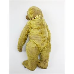 Early 20th century English teddy bear, with wood wool filled body with jointed limbs, felt covered paw pads, five claw stitching to feet and elongated arms with spoon shaped paws H14