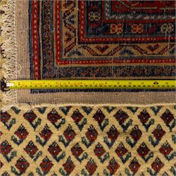 North West Persian Arak hand-knotted carpet, ivory ground densely decorated with an all-over diagonal boteh lattice design within a madder red main border of stylized rosettes and botehs between multiple narrow floral guard stripes