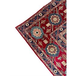 Persian Bakhtiari crimson ground carpet, the field divided into seventy panels decorated tree of life motifs, mihrabs and stylised plants, the border decorated with repeating circular medallions formed of Hac motifs, floral pattern guard stripes 