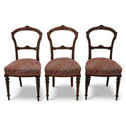 Set of six late Victorian mahogany dining chairs, the shaped top rails carved with anthemion motifs, above pierced splats, floral and geometric fabric seat, on turned and fluted front legs