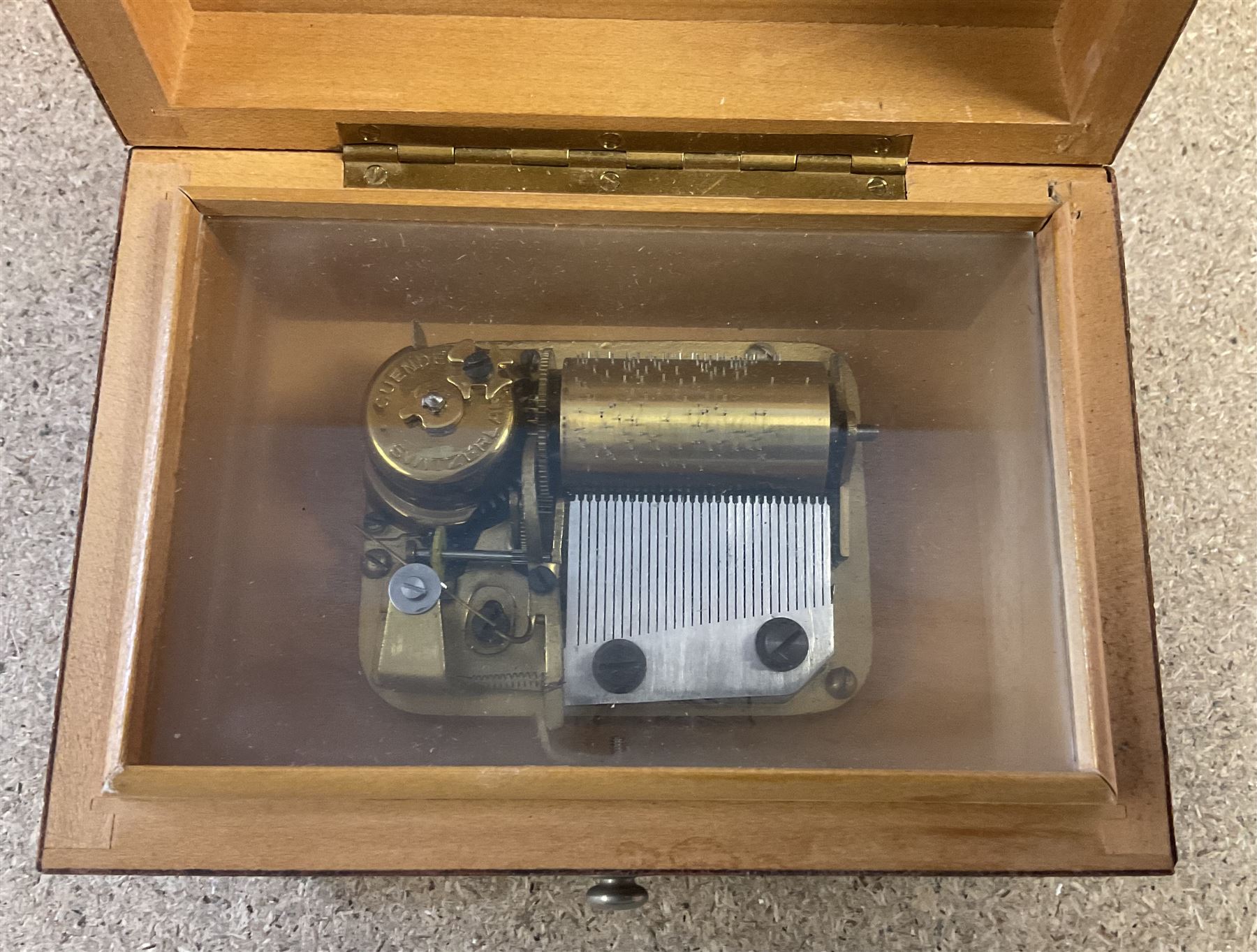 20th century burr wood Swiss musical box, marbled beneath 'made in Switzerland', paper label inscribed 'Around the world The Lass of Richmond Hill', H6.5cm W12.5cm D9cm