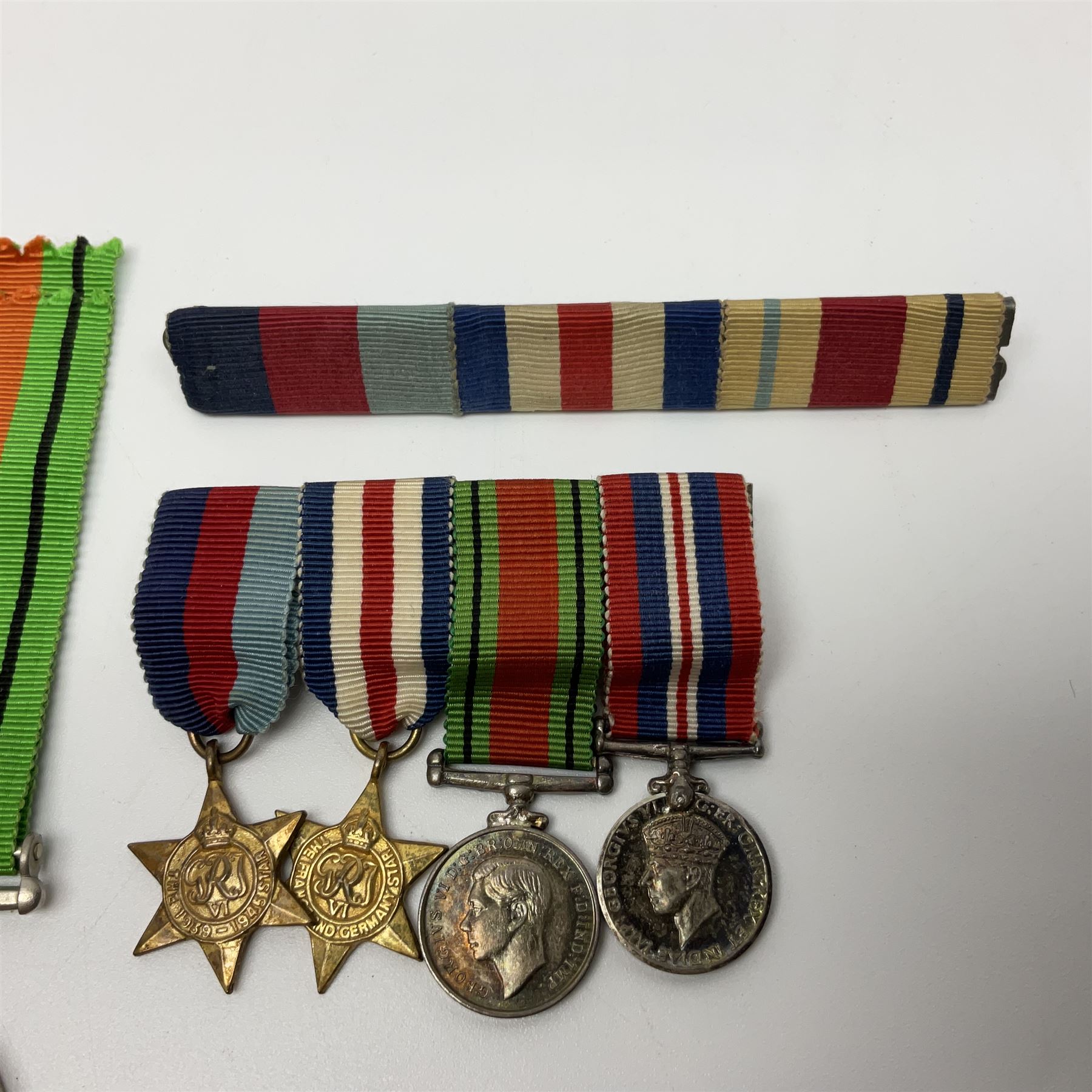 Ten WW2 medals comprising two 1939-1945 war medals, two Defence medals, two 1939-1945 Stars, two Africa Stars, France & Germany Star and Burma Star; together with bar of four miniature medals; all with ribbons