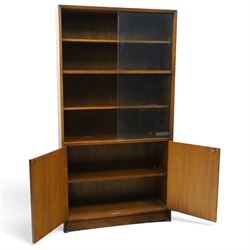 Herbert E Gibbs - Mid 20th century teak glazed bookcase cabinet, rectangular form with two sliding glazed doors enclosing adjustable shelves, lower cupboard enclosed by twin doors and fitted with internal shelf, on plinth base