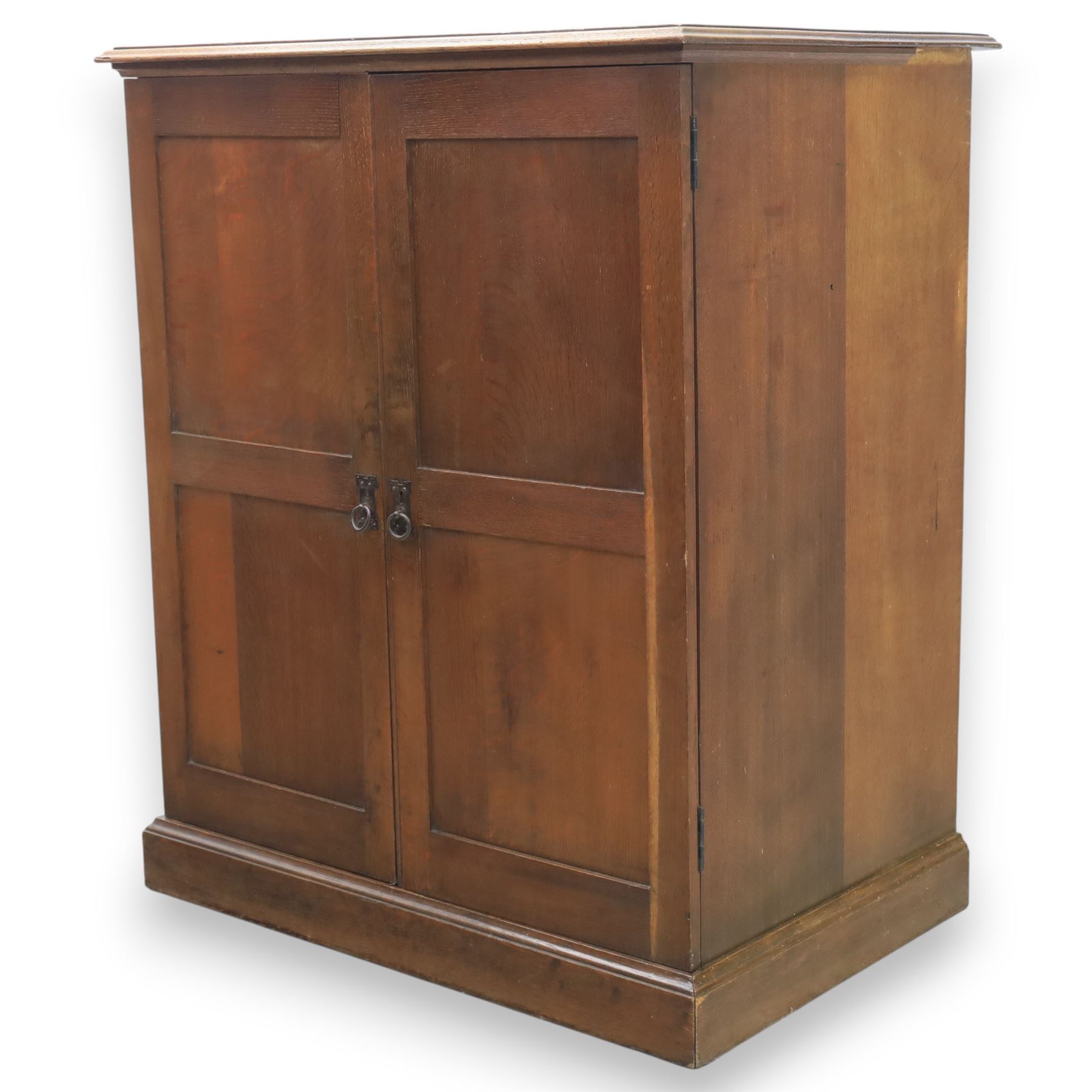 20th century oak Arts and Crafts fitted collector's cabinet, twin panelled doors with metal door pulls, enclosing a fitted interior, on a moulded plinth base