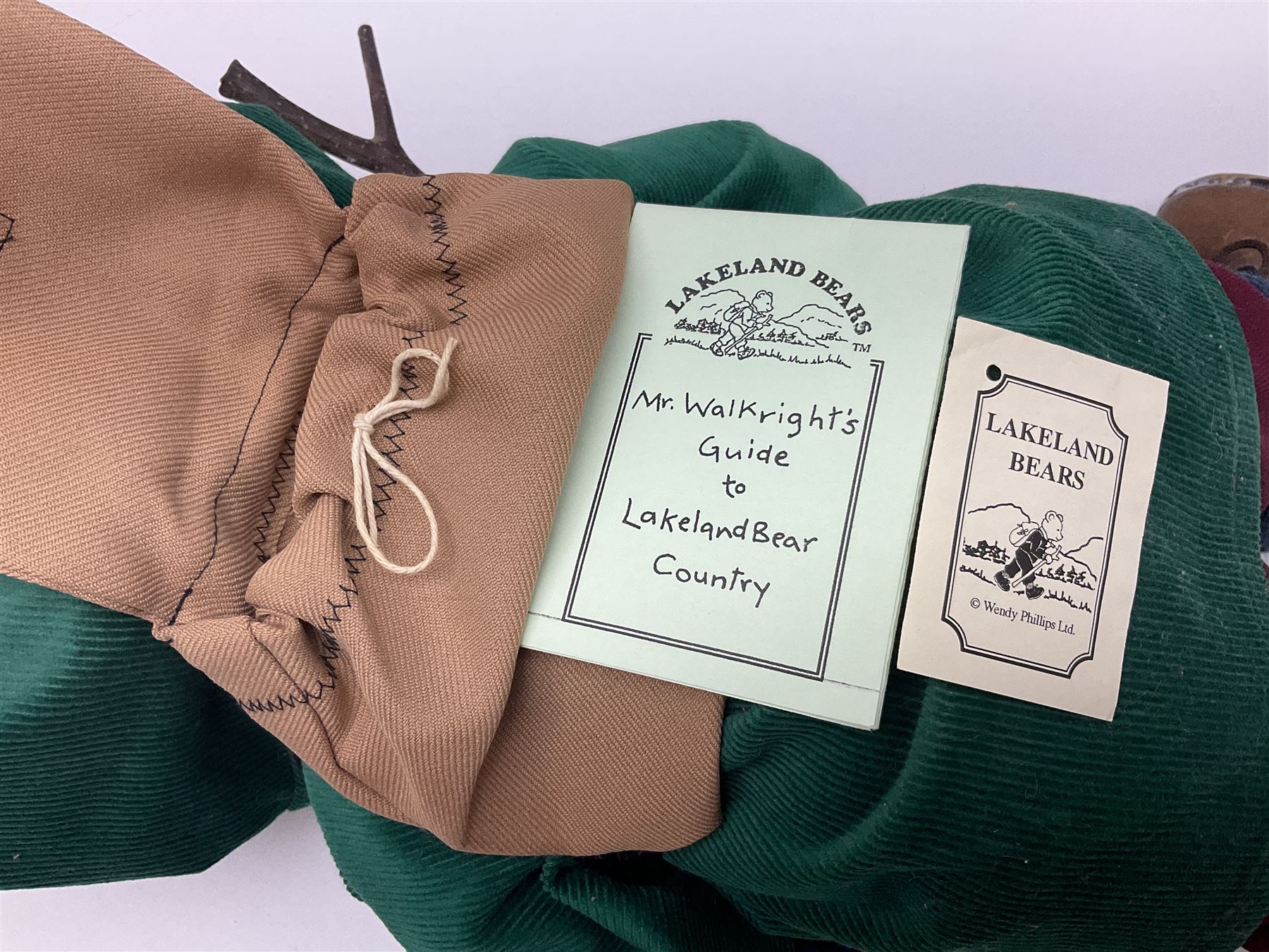 Lakeland Bears teddy bear, titled 'Walkright', dressed as a hiker in green corduroy duffle coat over fair isle jumper, trousers and knit socks, complete with leather clogs with wood soles, walkers thumb stick, knitted scarf, flat cap and rucksack housing original tag and map, H50cm