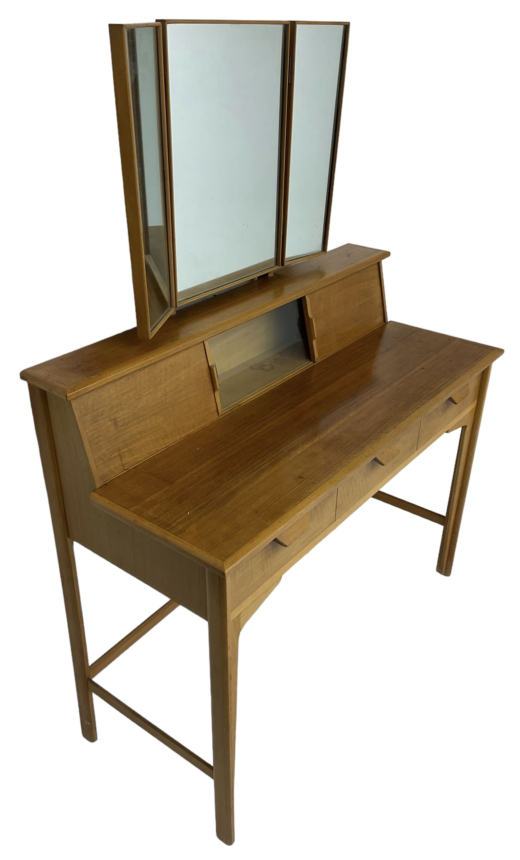 Heals of London - 1950s walnut and beech dressing table, raised triple mirror back over trinket compartments enclosed by sliding doors, above three drawers, on tapering supports