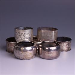 Seven silver napkin rings, of varying design and each with engraved initials, all hallmarked