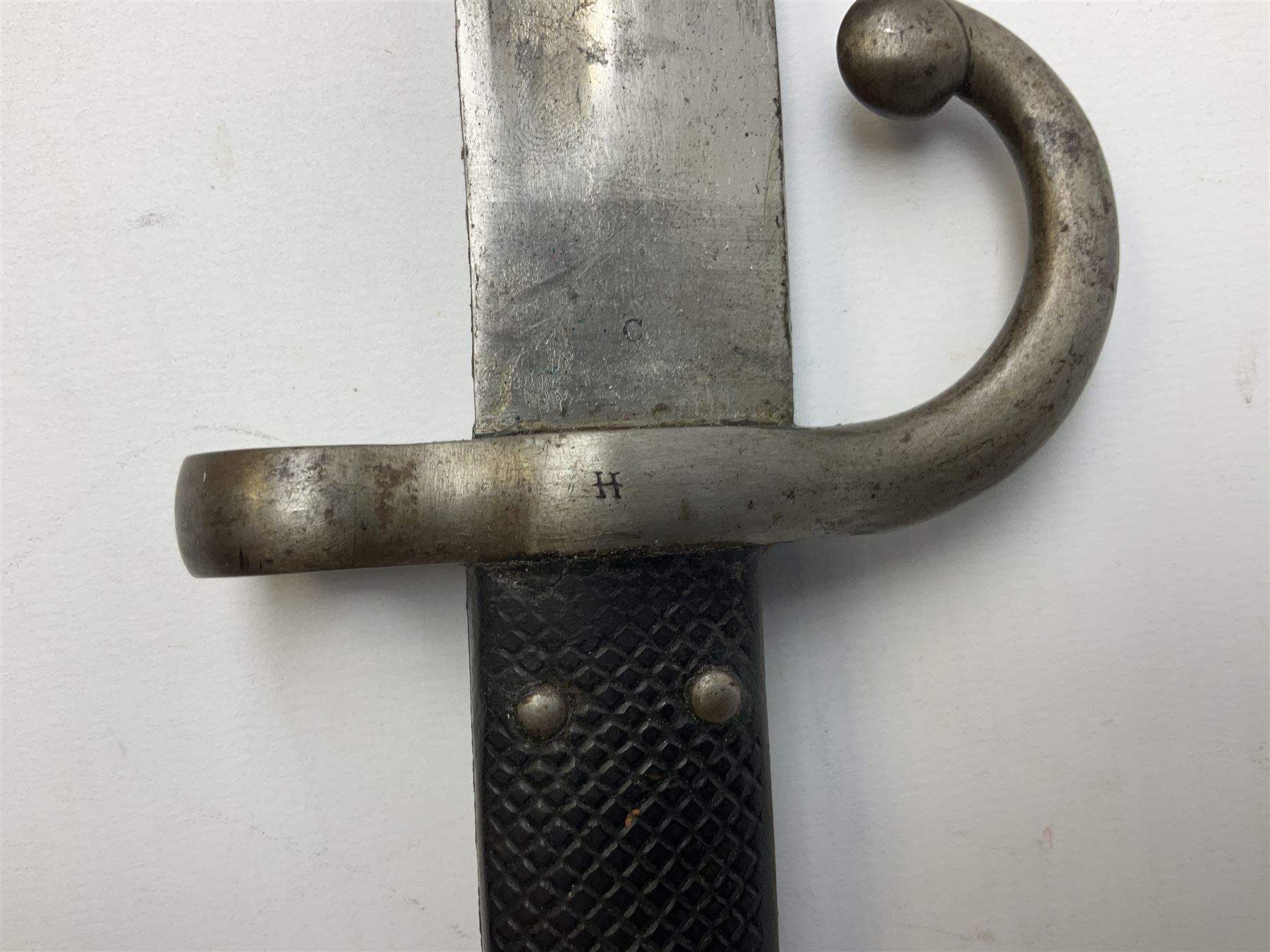 Turkish Model 1874 sword bayonet with 57.5cm curving steel fullered blade and chequered black grip, in steel mounted leather scabbard L75.5cm overall