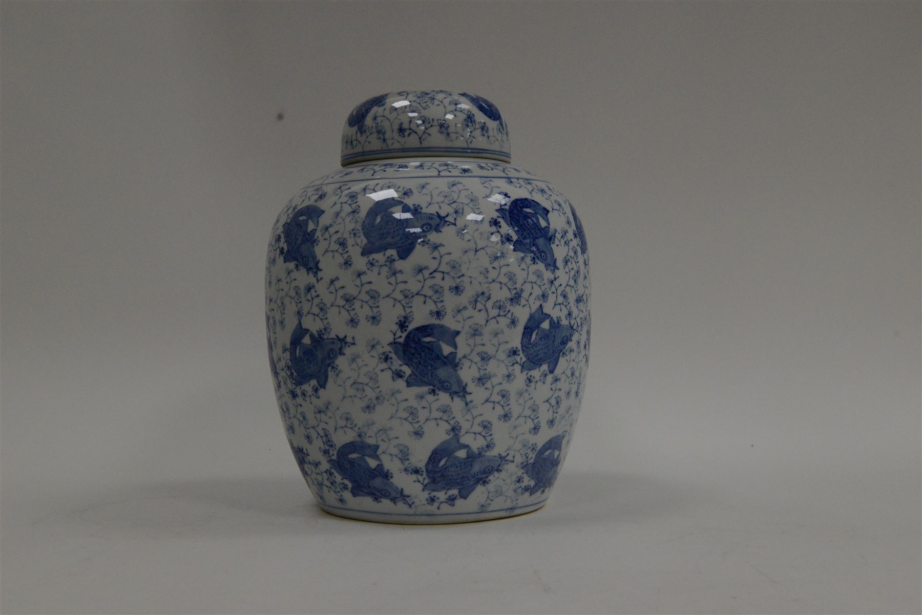 Blue and white ginger jar, decorated in a repetitive pattern of fish swimming amongst dense clusters of aquatic foliage, H40cm