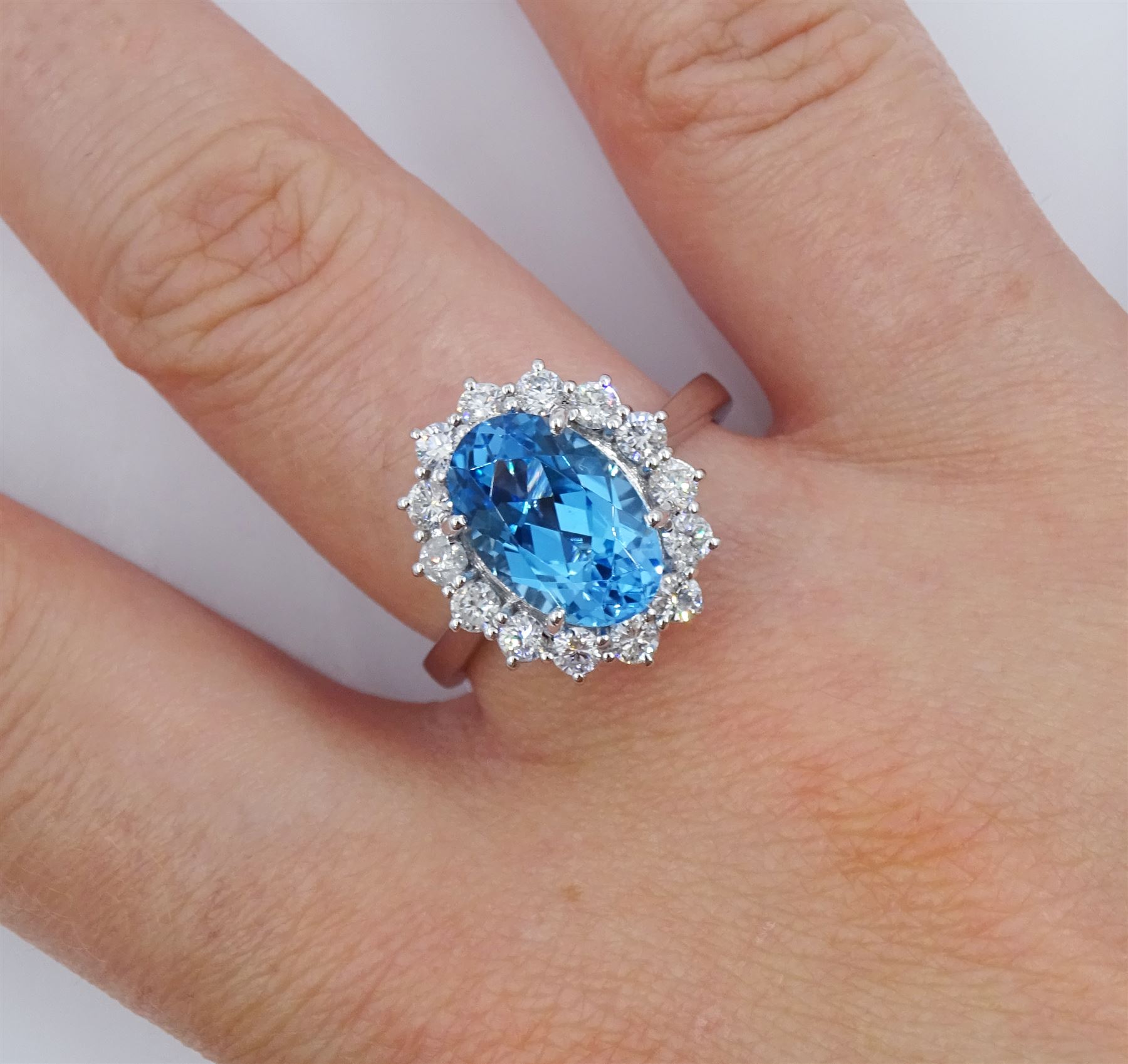18ct white gold oval cut Swiss blue topaz and round brilliant cut diamond cluster ring, hallmarked