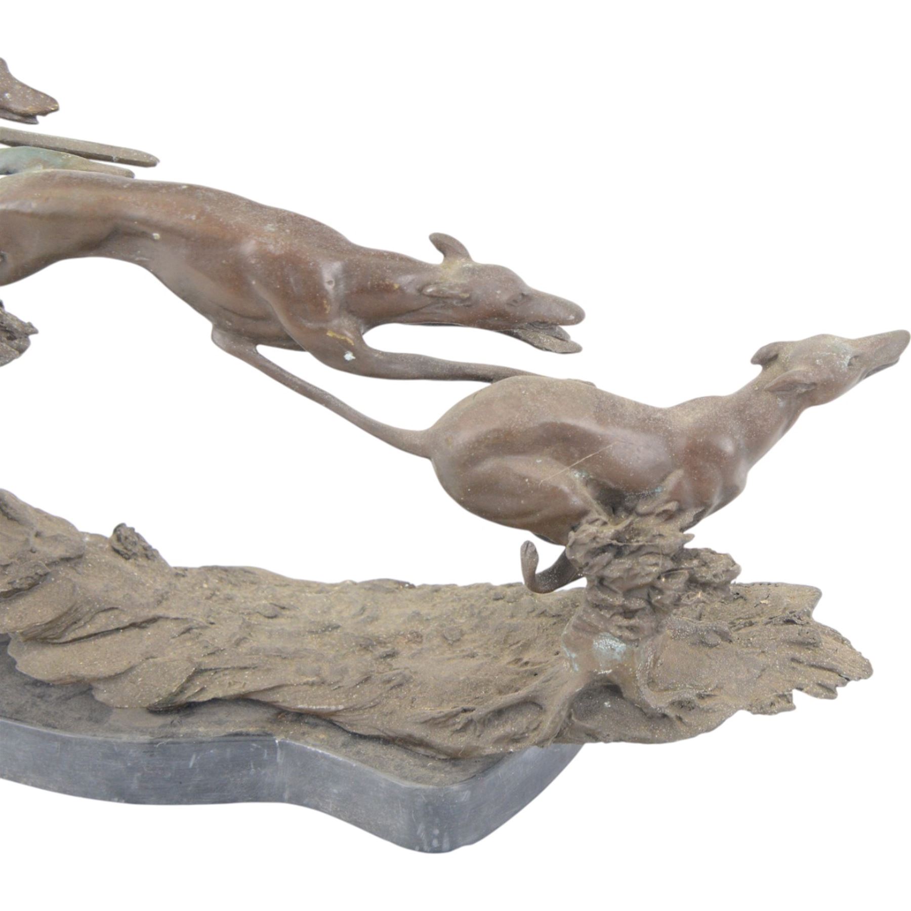 Bronzed sculpture of three greyhounds running at speed, on naturalistic base and oval plinth, L54cm H26cm 