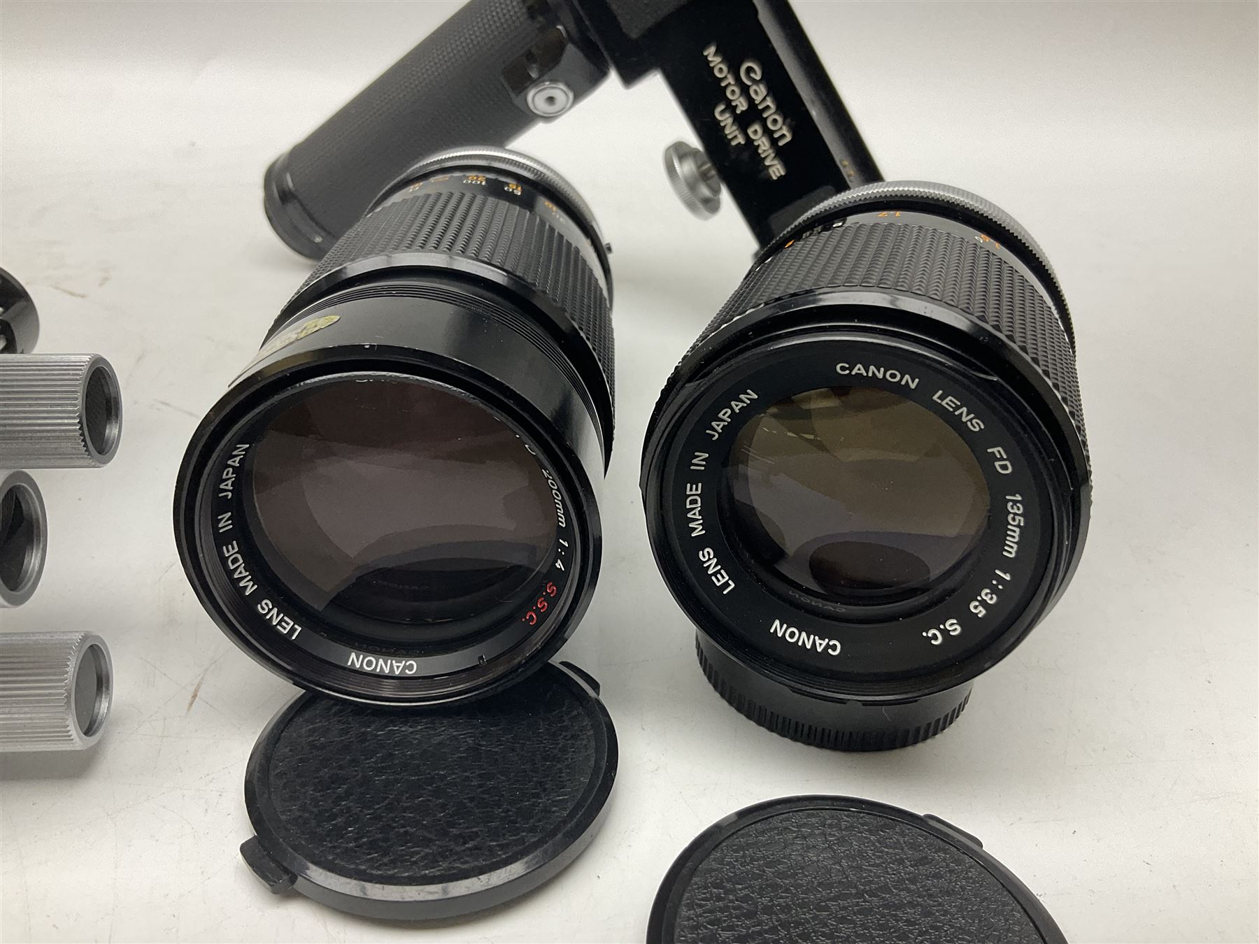 Collection of Canon lenses, to include 'Canon Lens FD 100mm 1:2.8', serial no 12821, 'Canon Lens FD 200mm 1:4' serial no 245313, 'Macro Canon Lens FL 50mm 1:3.5', serial no. 25505, 'Canon Lens FD 135mm 1:3.5 etc, together with other Canon equipment, including Bellows FL, Slide Duplicator etc 