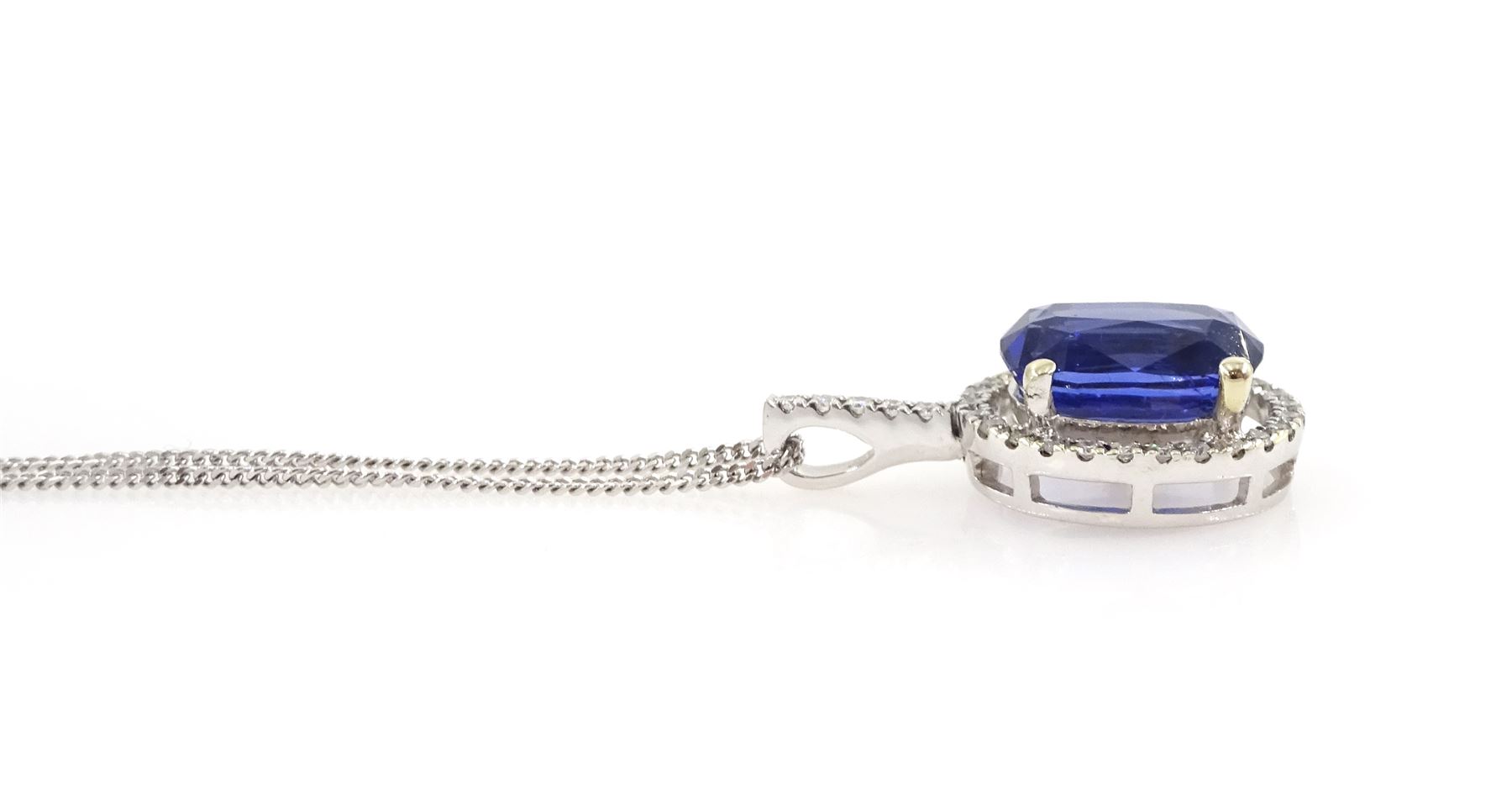 18ct white gold sapphire and diamond halo pendant necklace, single cushion cut sapphire of approx 4.65 carat, with round brilliant cut diamond surround and bail, on fine flattened curb link chain necklace, both hallmarked, total diamond weight approx 0.35 carat