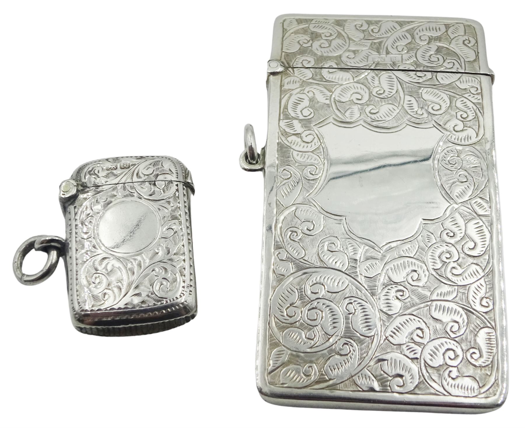 Edwardian silver card case, of curved oblong form, engraved with vacant cartouche surrounded by foliate scrolls, hallmarked Henry Matthews, Birmingham 1905, W8.5cm, together with an Edwardian silver vesta case, of rounded rectangular form, engraved with vacant circular panel surrounded by foliate scrolls, hallmarked William Neale, Chester 1901, approximate total weight 1.66 ozt (51.8 grams)