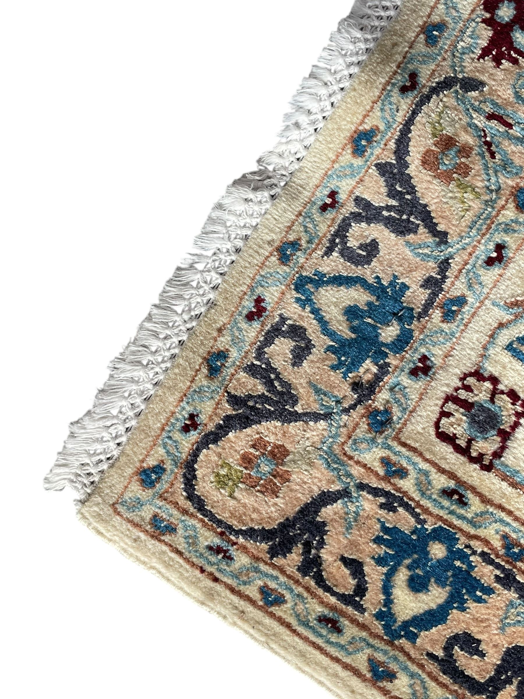 Persian Nain blue and ivory ground rug, wool with silk inlay, overall arabesque design, central medallion surrounded by interlacing and scrolled leafy branches and palmettes, the scrolling border decorated with stylised plant motifs, within guard stripes