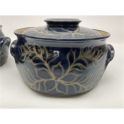 John Egerton (c1945-): set of two studio pottery stoneware twin handled jars with covers, decorated with floral and foliate sprigs upon a dark blue ground, D23cm, H15cm