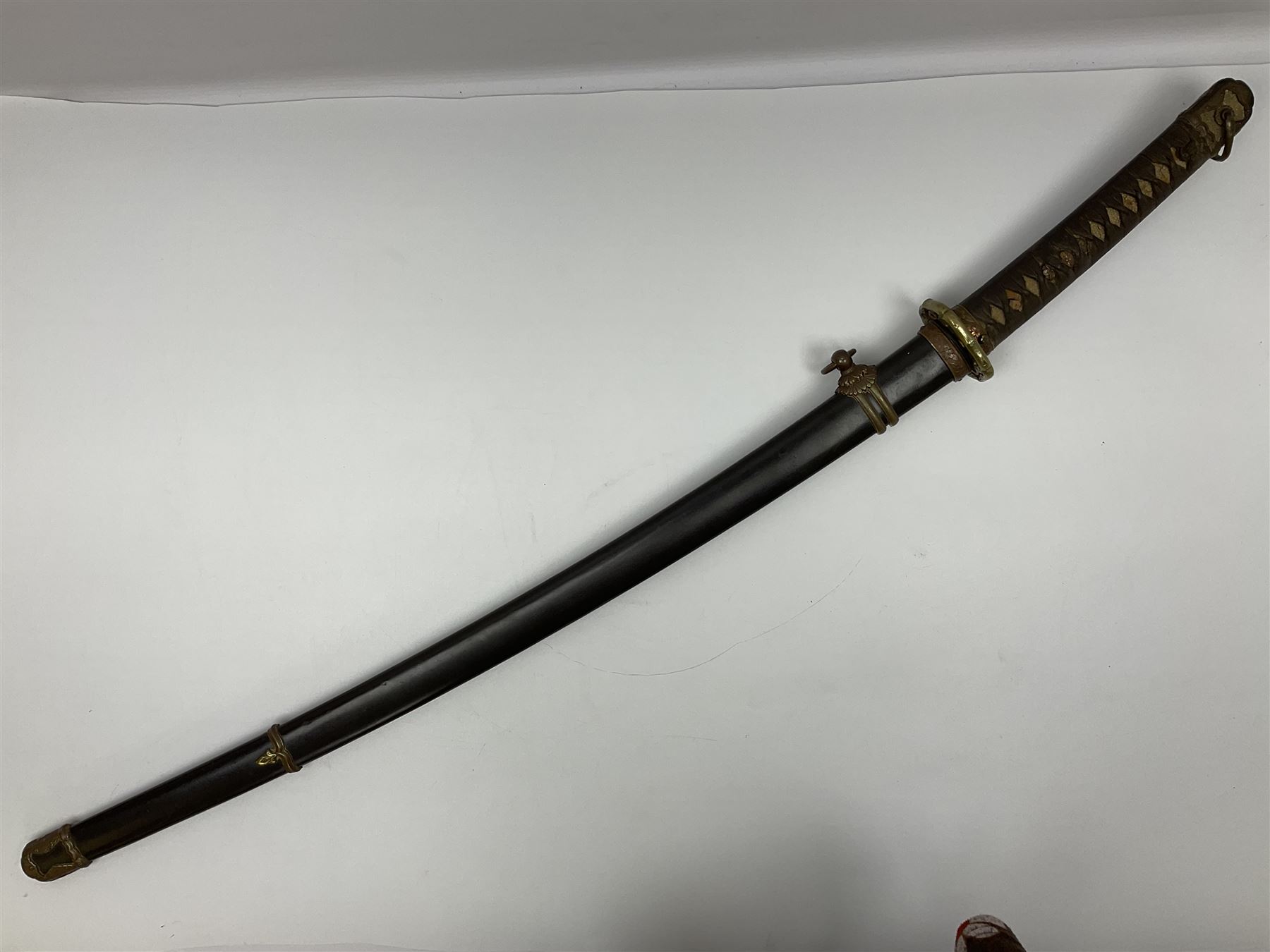 WW2 Japanese Army officer's shin gunto/katana sword with 68.5cm steel single edged blade, foliate cast brass tsuba, bound fish-skin grip with brass mounts, inscribed marks to both sides of tang; in lacquered wooden scabbard with brass mounts and locking button L97cm overall