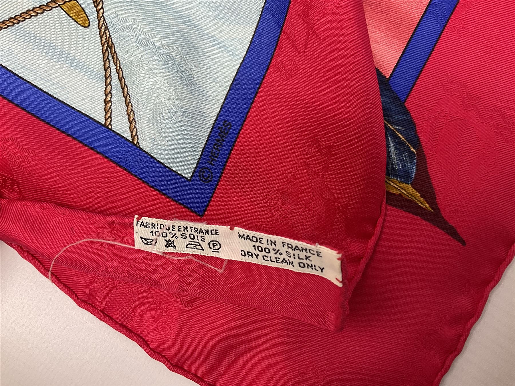 Hermès 'Christophe Colomb Découvre l'Amérique' jacquard silk scarf, designed by Carl de Parcevaux in 1992, limited edition for the bi-centenary of the discovery of America, printed with a central image of Christopher Columbus' ship at sea, surrounded with colourful stylised feathers, birds, flags, globes, shells and flowers, contained within vibrant red border, with rolled hand stitched edges and Hermes material label, 87cm square