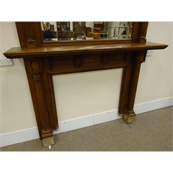  Edwardian oak fire-surround, raised bevel edge mirror back, projecting moulded cornice above single shelf with dentil frieze, two reeded columns flanking central aperture, W190cm, H217cm, D37cm  