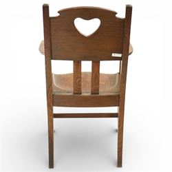 Arts and Crafts oak armchair, the shaped back with heart-shaped pierced splat above three vertical slats, solid dished seat with rounded front, open arms on turned front supports, square section legs united by plain stretchers