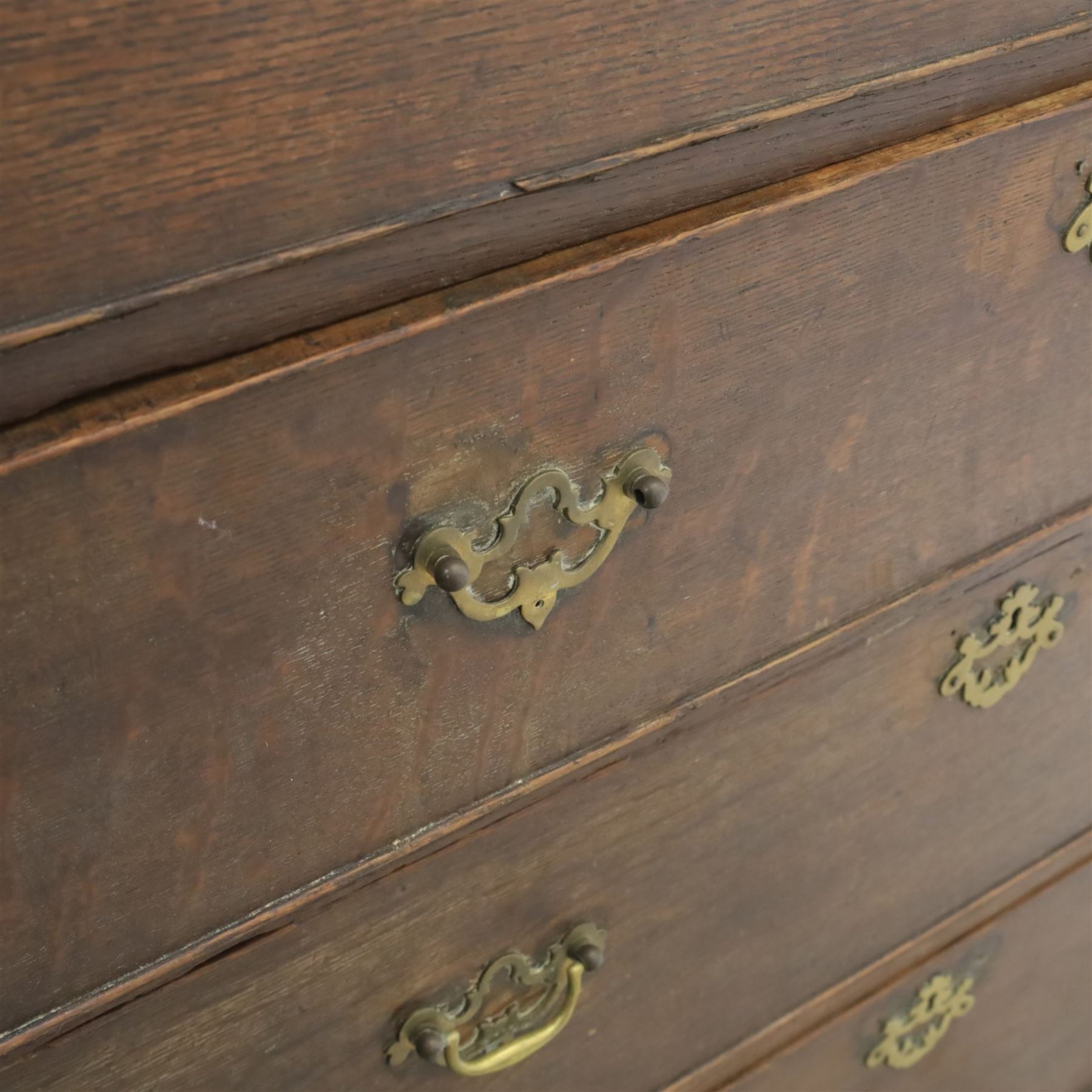 18th century oak chest, rectangular top with moulded edge, fitted with five drawers and baize line slide, with swan neck brass handles, raised on bracket feet