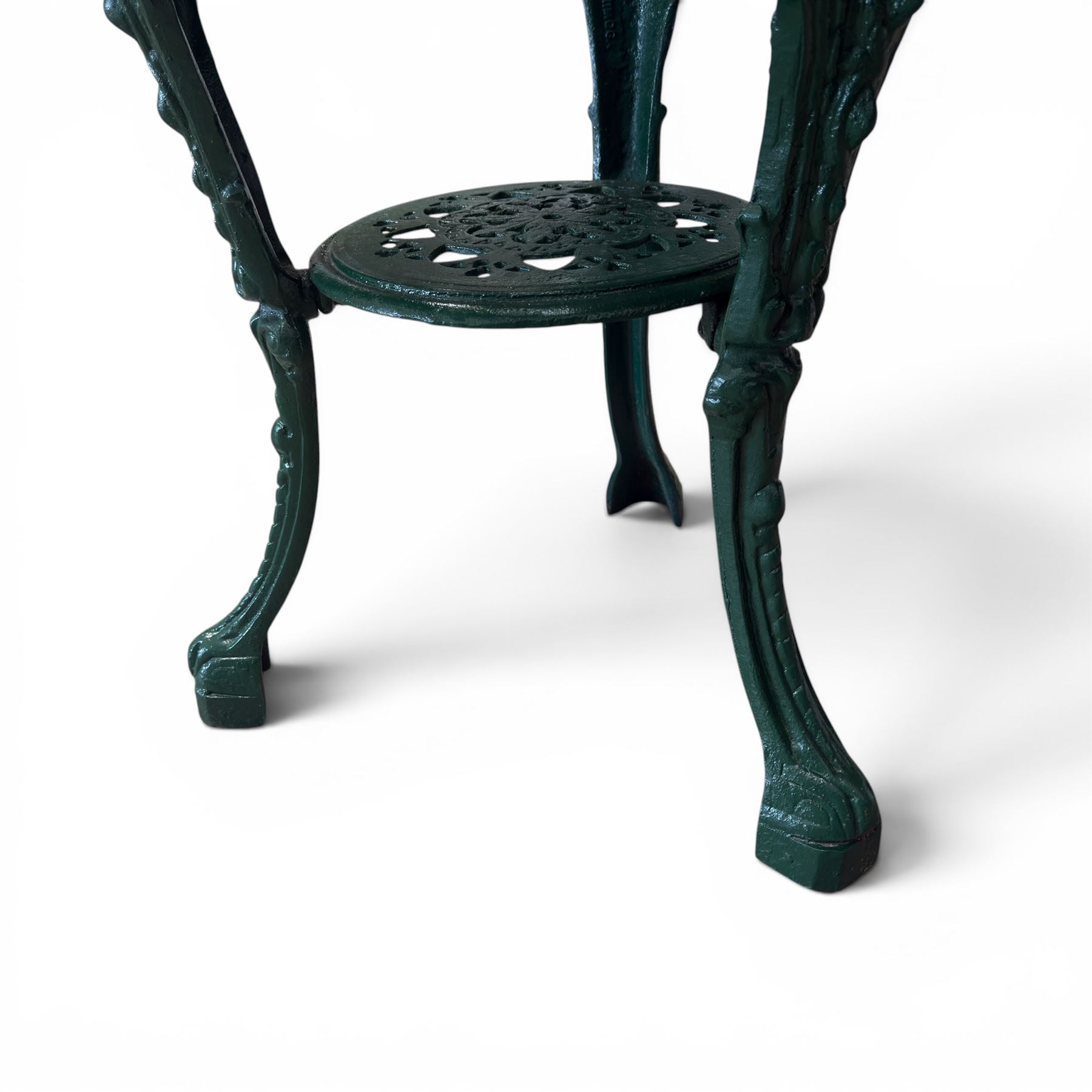 Painted cast iron garden table, the circular pierced top with foliate decoration and egg-and-dart rim, raised on three cloven hoof supports with classical female mask knees, united by pierced undertier, in green-painted finish