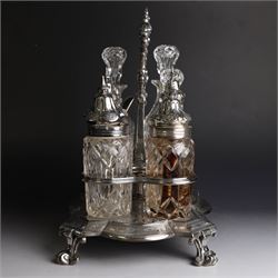 Victorian silver cruet stand, containing eight cut glass cruet bottles, four with silver covers, upon a shaped base with four scroll feet and loop handle, chased with floral and foliate decoration, the stand, base and bottle caps all hallmarked John, Edward, Walter & John Barnard, London 1872, one bottle with a matched silver cruet spoon, stand H30cm