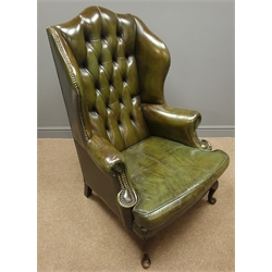  Georgian style wingback armchair, upholstered in buttoned green leather, with studded detailing, front cabriole supports and two square supports to the rear, W77cm, H117cm, D70cm  