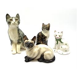 A Winstanley cat, with glass eyes in seated post, signed beneath, H25cm, together with three other figures of cats, including a Rye Pottery example. (4). 