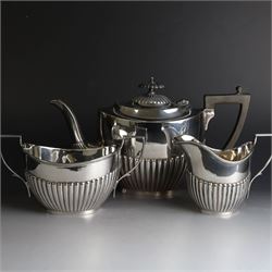1920s silver three piece tea service, comprising teapot, twin handled open sucrier and milk jug, each of oval part fluted form, the teapot with Bakelite type handle and finial, hallmarked Cooper Brothers & Sons Ltd, Sheffield 1922