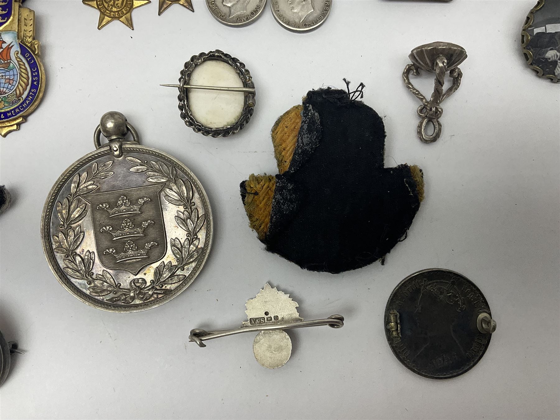 Collectables, to include enamelled Gothic Florin, Hull Rudston and Preston 1811 one shilling six pence token, silver gilt Hull Airedale Terrier Club fob, silver and tortoiseshell badge inscribed East Yorkshire beneath Yorkshire Rose, polychrome enamel buckle, mother of pearl badge carved with rose and tiger and inscribed York & Lancaster, etc.