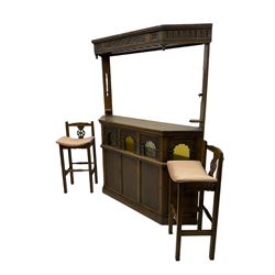 Old Charm - oak corner bar, the canopy frieze carved with scrolls, front decorated with arched apertures glazed with bullseye and mottled glass panes, skirted base, together with two bar stools