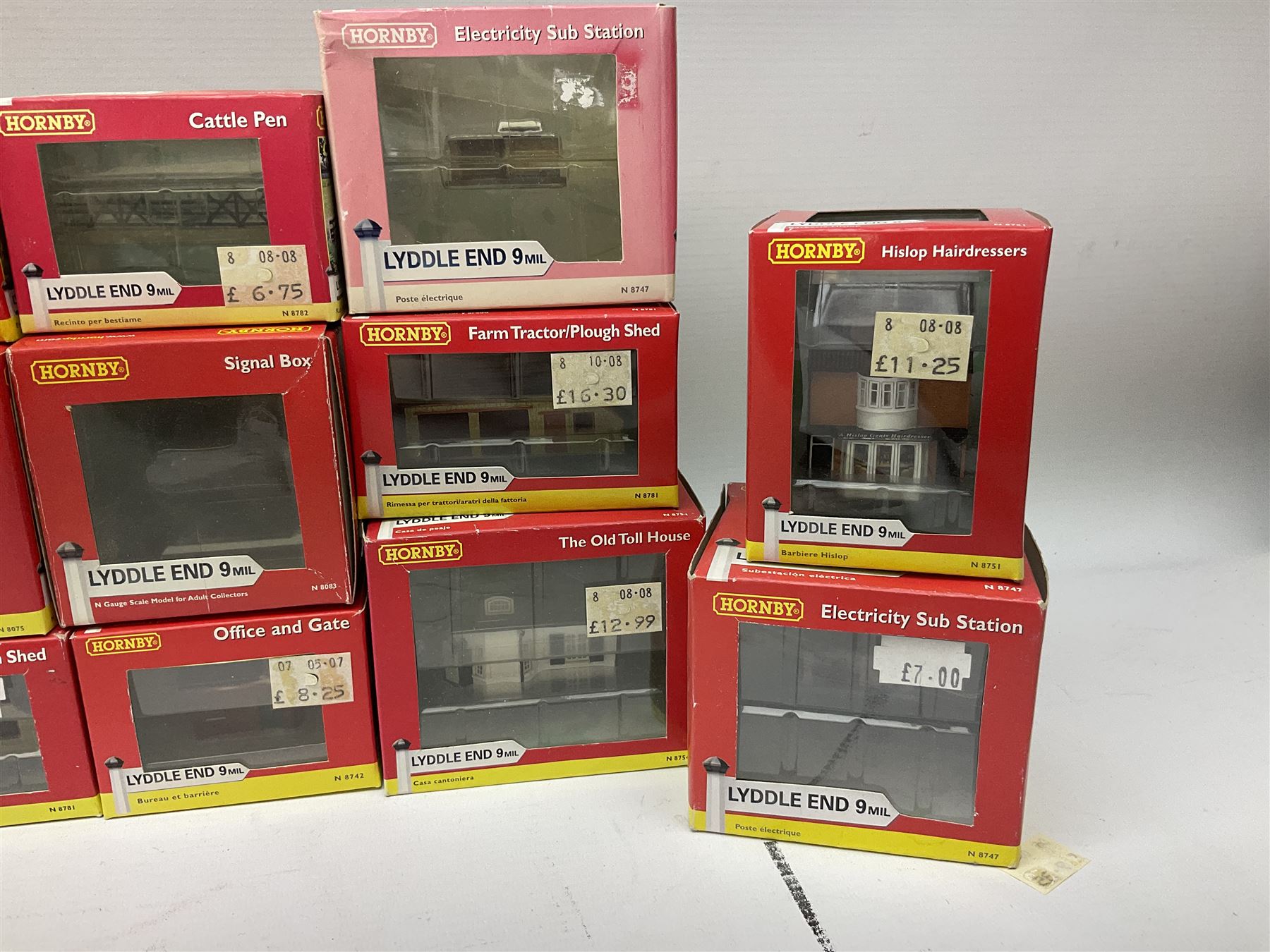 Hornby 'N' gauge - eighteen Lyddle End trackside buildings including The Old Toll House, Electricity Sub Station, Teesdale bakery, Mason's Arms Pub, various shops and hairdressers, farm buildings, Clock Tower etc; all boxed; and five Lyddle End blister pack cards of trackside accessories including Lamp Huts, Tractors, War memorial etc (23)