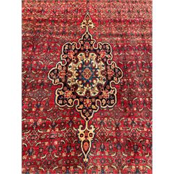 North West Persian Bidjar red ground carpet, the central foliate pole medallion in a field with matching spandrels and all-over Herati decoration, the guarded border decorated with repeating palmette motifs and scrolling foliate branches