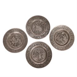 Set of four Persian silvered copper plates, decorated in relief, the central panel depicti...